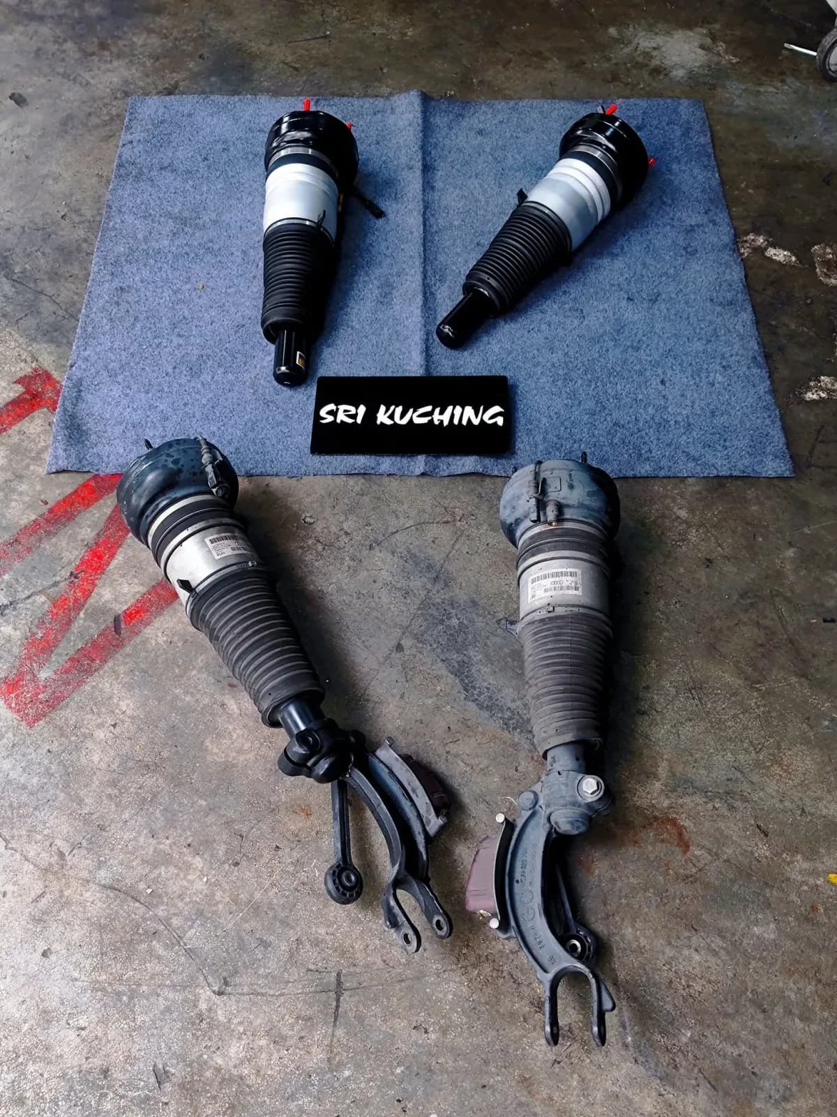 Removed and replacement Audi A8 front air strut assemblies laid out in the workshop