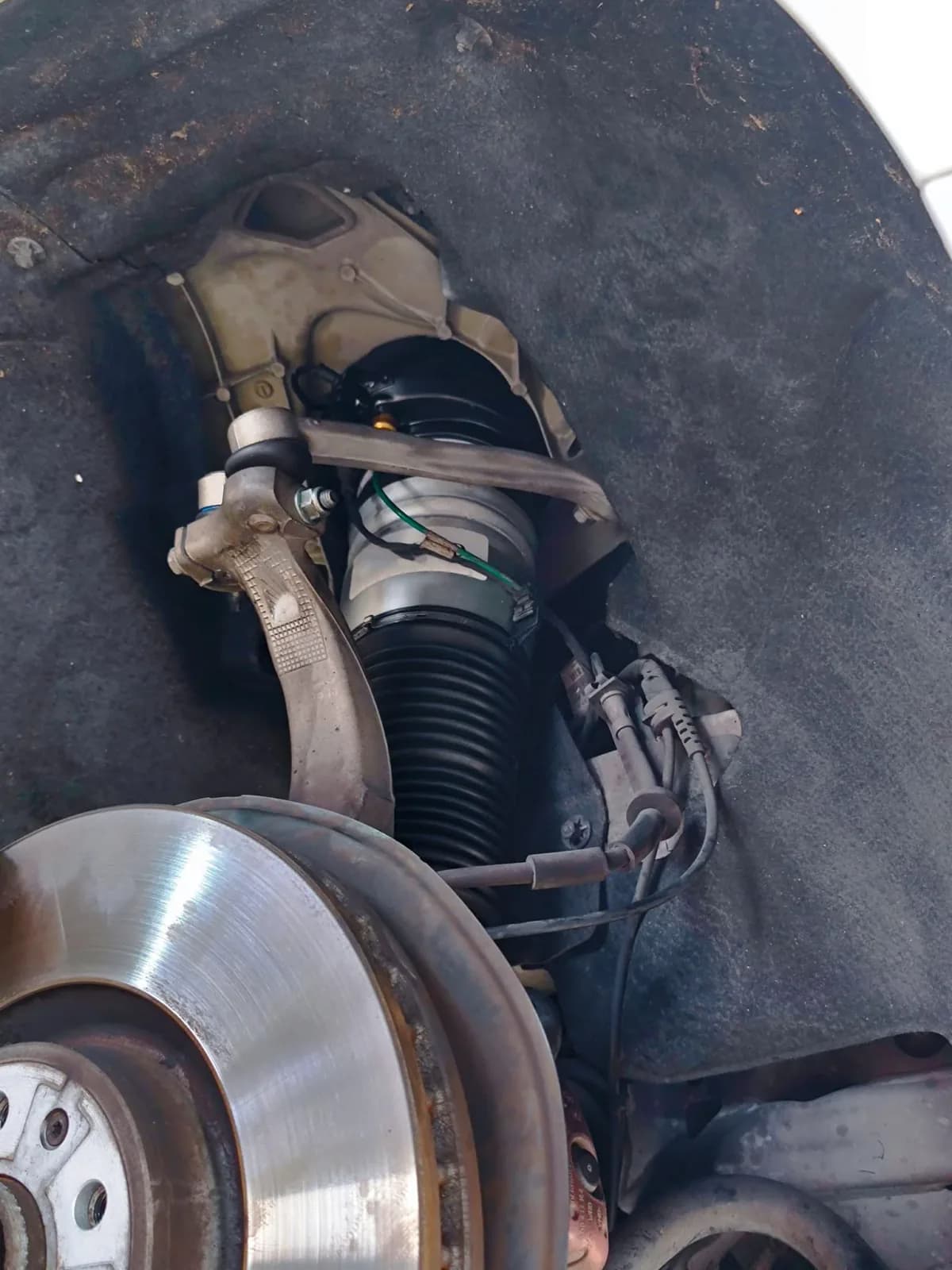 Audi A8 air strut visible inside the front wheel arch with the wheel removed