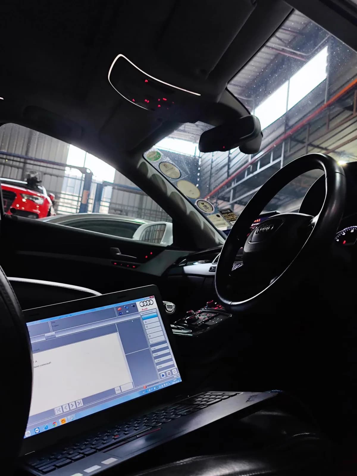 Diagnostic laptop inside the Audi A8 during the air suspension workshop case